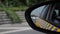Cars traffic along road view in left side mirror of auto