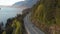Cars travelling down a beautiful epic coastal highway on the side of a mountain near Horseshoe Bay, West Vancouver.