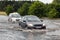 Cars trying to drive against flood on the street in Gdansk, Poland.