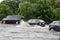 Cars trying to drive against flood on the street in Gdansk, Poland.