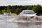 Cars trying to drive against flood on the street in Gdansk, Poland.