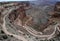 Cars on windy dirt road across the canyon