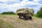 A cart with hay bales on a mown meadow. Haymaking in the village.