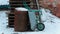 Cart rusty barrel and a stack of wooden pallets in the winter