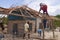Cartagena de Indias, Colombia - Nov 21, 2010: A group of men repair the roof of a humble wooden house, broken after a storm, on