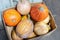 Carton box with many multicolored ripe fresh raw organic pumpkin at farmer market. Autumn halloween background