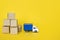 Carton boxes and post truck on yellow background. Cargo transportation, delivery service.