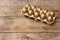 Carton with golden eggs on wooden table