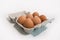 Carton of six eggs on a white table. Shallow depth of field.
