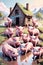 Cartoon animal character of the cute and adorable piglets in a mud puddles in a farm with a farm house and mountains, printable