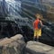 Cartoon athletic man stands on a rock beside a huge waterfall