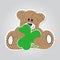 Cartoon - brown, furry smiling bear with clover