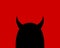 Cartoon devil character on a red background. Silhouette of a black horned head