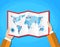 Cartoon hands hold folded paper map of world with color point markers. World map countries. vector illustration in flat