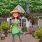 Cartoon joyful woman gardener standing in the yard of the house