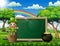 Cartoon leprechaun sitting above chalkboard with a nature landscape