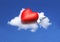 Cartoon red heart resting on a pillow above a cloud
