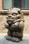 A cartoon-shaped stone lion is placed in front of an old factory building in the 798 Art District