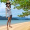 Cartoon smiling girl in a hat stands on the seashore