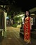 Cartoon woman in national dress stands on the evening street