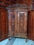 carved antique wooden wardrobe. an ancient cupboard is located in a room against a backdrop of thick wooden walls