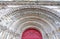 Carved arch above the red church entrance door. Bordeaux, France