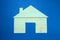 Carved blue cardboard house on wooden background