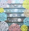 Carved colorful paper snowflakes on a blue wooden background