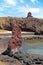 Carved figure in volcanic stone near the village of Hanga Roa, on Easer Island, against the ocean and a blue sky covered