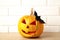 Carved glowing pumpkin and black bat on light background. Halloween celebration