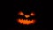 Carved halloween pumpkin glowing in dark, Jack lantern face, scary flying decor