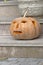  Carved Halloween pumpkin on a house ladder 