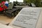 Carved poems about war against background of destroyed tank
