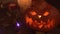 Carved pumpkin lantern for Halloween decoration flickers in smoke close-up