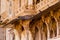 Carved sandstone exterior walls of the udaipur palace with arches, balcony and windows