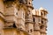 Carved sandstone exterior walls of the udaipur palace with arches, balcony and windows