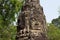 Carved tower bas-relief of Angkor Wat complex temple, Siem Reap, Cambodia. Buddha face stone carving