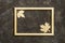 Carved wooden leaves on a wooden frame lying on dark background. Top view. Copy space. Autumn concept.