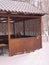 carved wooden outdoor porch terrace in a winter park on a background of snowy trees.  mobile photography