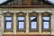 Carved wooden platbands on the windows of an old building, a fragment of the facade
