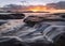 Cascade pouring over rocks at sunrise at Umina Beach on the Central Coast, NSW in Australia