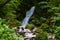 Cascade of a small waterfall flowing through the forest