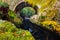 Cascade under bridge on mountain stream, between mossy rocks in Tollymore Forest Park