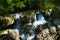 Cascade of waterfalls. Stormy flow of water of a mountain river.