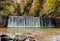 Cascades on stream surrounded by beautiful woodland in autumn