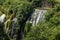 Cascades of waterfalls among ancient ruins in vegetation