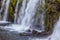 The cascading waterfall on the mossy cliff