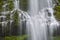 Cascading waterfall with rows of spilled water and green mossy rocks