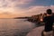 Cascais, Portugal - 29 September 2020 - Young man in viewpoint photographing cliffs and sunset with smartphone in Boca do Inferno