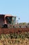 Case Combine cutting Milo in the fall with tree`s and blue sky in Kansas.